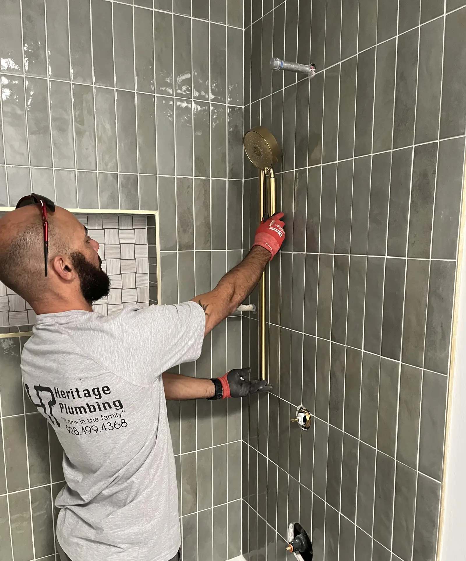 Heritage Plumbing plumber installing a shower bar